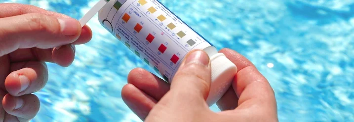Person testet Wasserqualität im Pool